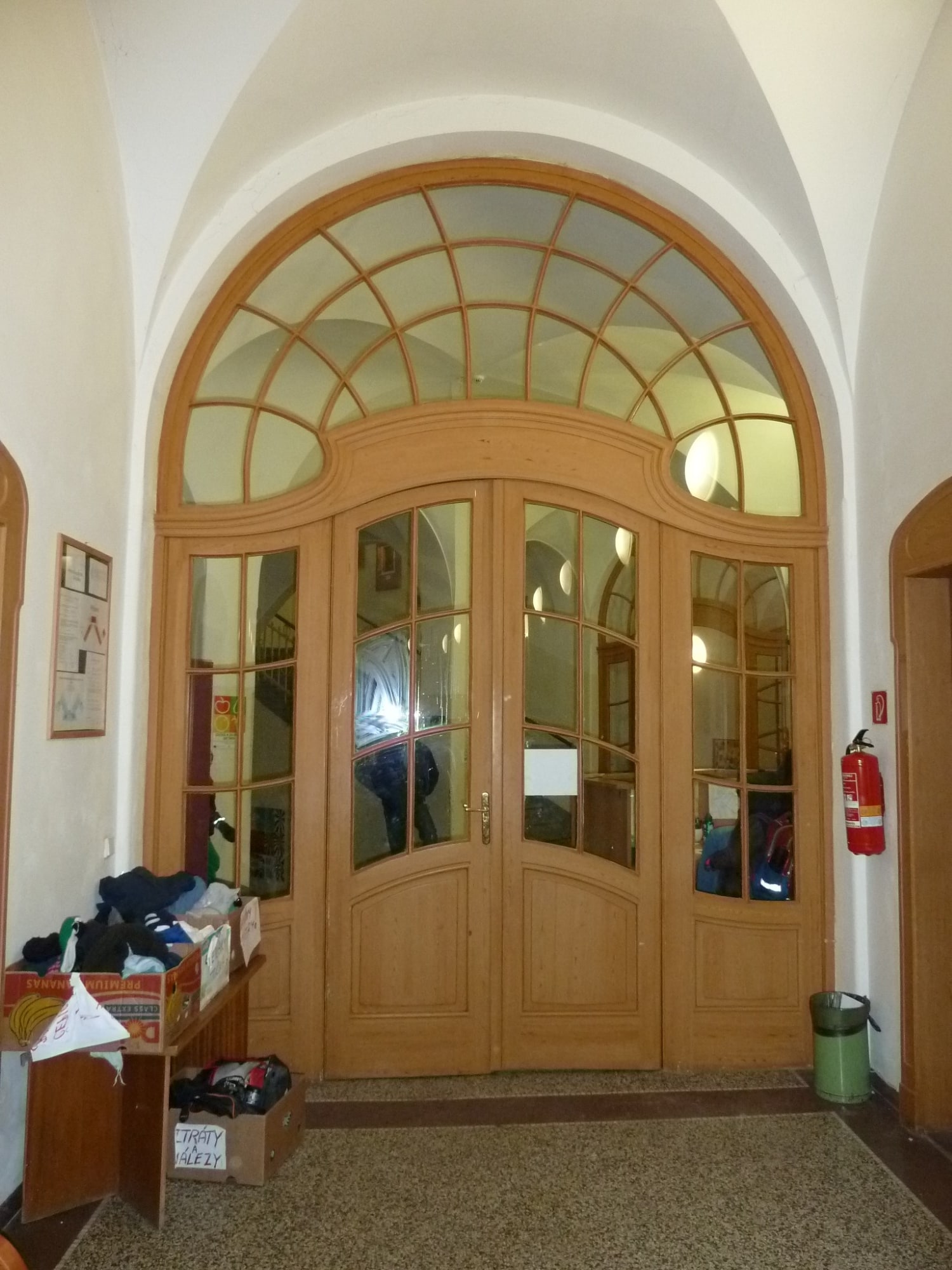 Prosklená protipožární stěna s replikou historických dveří ve vstupní hale školy